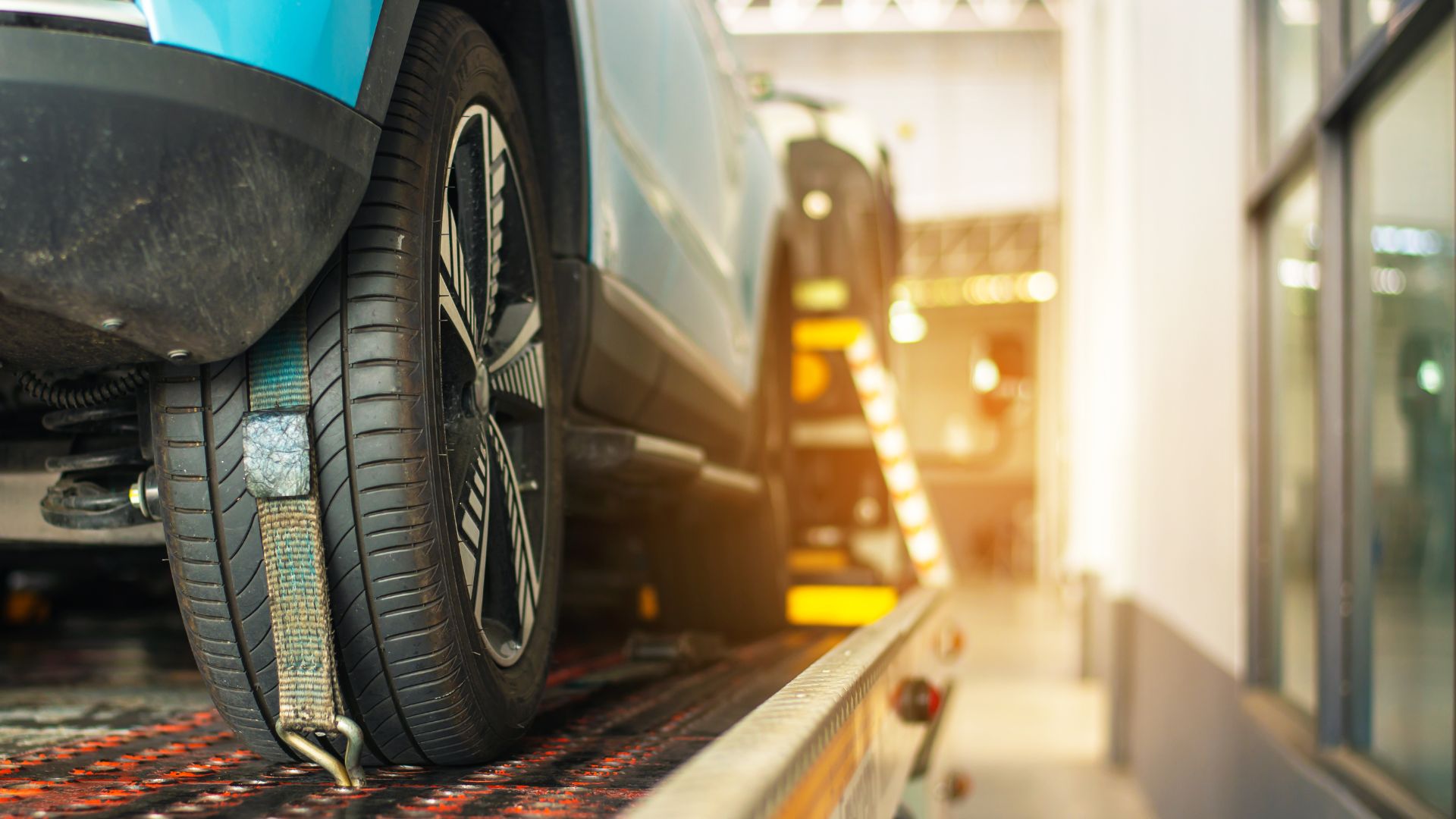 Car tire on platform with blurred automotive service background